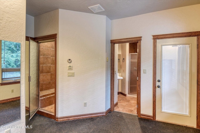 225 Fairway Dr, Priest Lake, ID 83856 - unfurnished bedroom with a textured wall, carpet flooring, ensuite bath, and baseboards