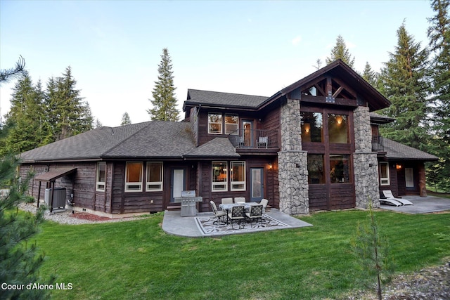 225 Fairway Dr, Priest Lake, ID 83856 - back of house featuring a balcony, a patio, a yard, and a shingled roof