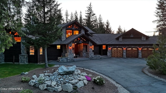 225 Fairway Dr, Priest Lake, ID 83856 - view of front of home with stone siding, asphalt driveway, and a garage