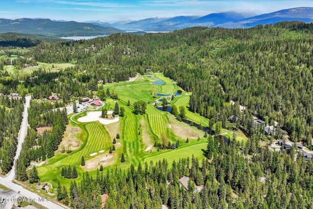 225 Fairway Dr, Priest Lake, ID 83856 - aerial view of property and surrounding area with a forest, a mountain backdrop, and a local golf course