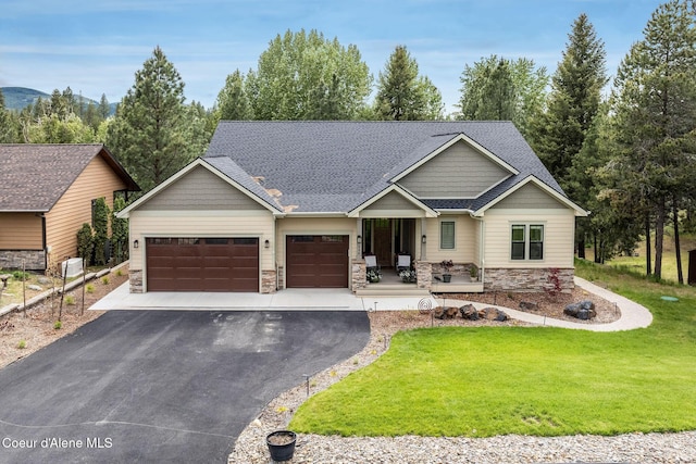 396 Hanaford Rd, Blanchard, ID 83804 - craftsman house featuring stone siding, asphalt driveway, a front lawn, a garage, and covered porch