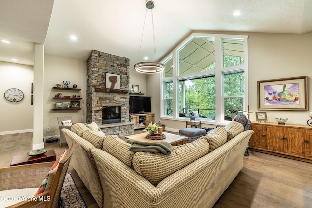 396 Hanaford Rd, Blanchard, ID 83804 - living area featuring vaulted ceiling, a stone fireplace, light wood-type flooring, recessed lighting, and baseboards