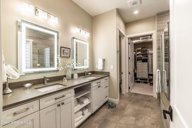 396 Hanaford Rd, Blanchard, ID 83804 - full bathroom with double vanity, a walk in closet, tiled shower, and recessed lighting