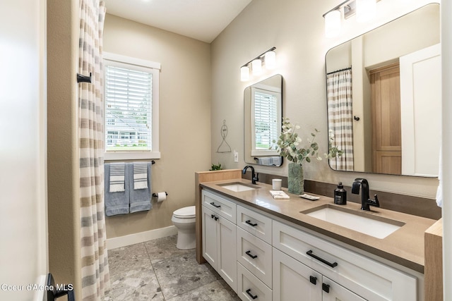 396 Hanaford Rd, Blanchard, ID 83804 - bathroom with double vanity, toilet, healthy amount of natural light, and baseboards
