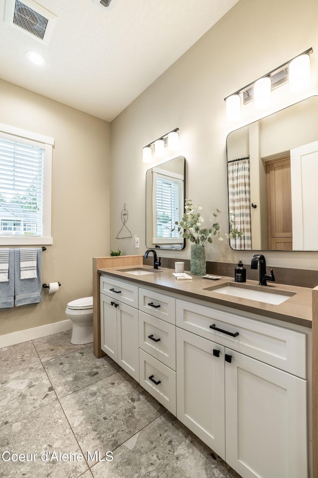 396 Hanaford Rd, Blanchard, ID 83804 - full bath with double vanity, toilet, plenty of natural light, and baseboards