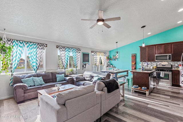 3283 N Knob Creek Ct, Post Falls, ID 83854 - living area featuring a ceiling fan, light wood-style flooring, vaulted ceiling, a textured ceiling, and recessed lighting