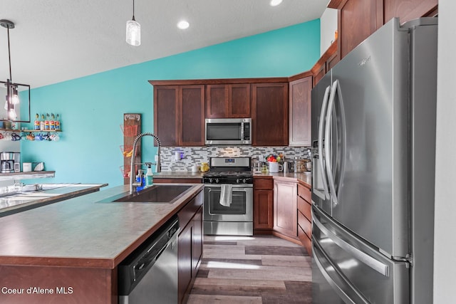 3283 N Knob Creek Ct, Post Falls, ID 83854 - kitchen featuring stainless steel appliances, a sink, lofted ceiling, light wood finished floors, and decorative backsplash