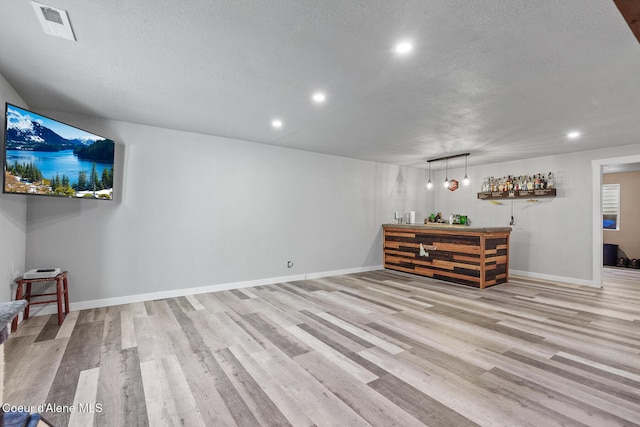 3283 N Knob Creek Ct, Post Falls, ID 83854 - living room with a textured ceiling, a bar, light wood-type flooring, recessed lighting, and baseboards
