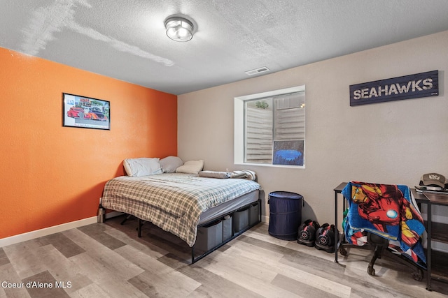 3283 N Knob Creek Ct, Post Falls, ID 83854 - bedroom with light wood-style floors, a textured ceiling, and a textured wall