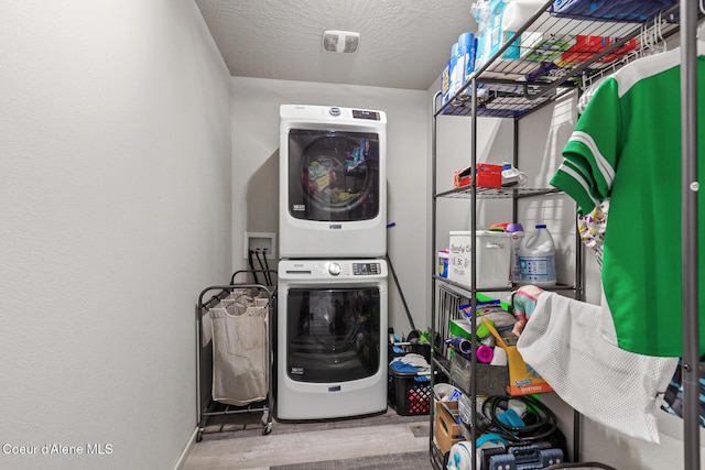 3283 N Knob Creek Ct, Post Falls, ID 83854 - laundry area with stacked washing machine and dryer, wood finished floors, and baseboards