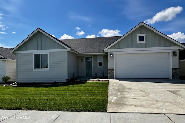 3387 N Cyprus Fox Loop, Post Falls, ID 83854 - view of front facade featuring board and batten siding, a shingled roof, driveway, a front lawn, and a garage
