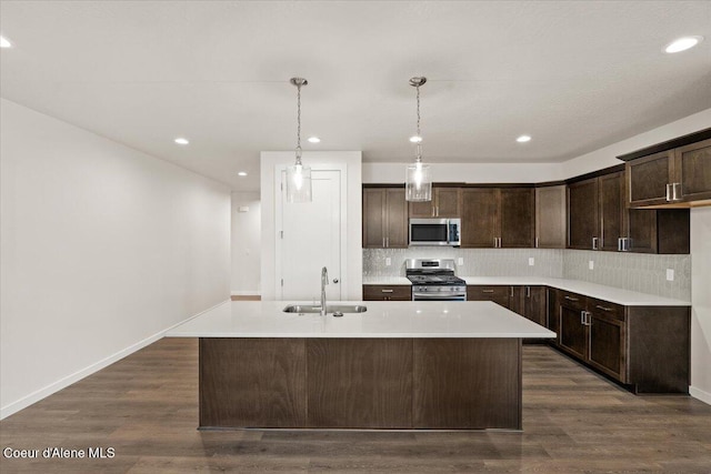 3387 N Cyprus Fox Loop, Post Falls, ID 83854 - kitchen with stainless steel appliances, a sink, dark brown cabinetry, backsplash, and a kitchen island with sink