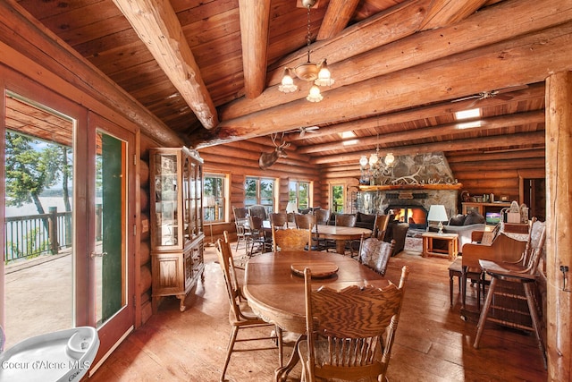 8457 N Powell Way, Hayden, ID 83835 - dining space featuring wood ceiling with exposed beams, log walls, wood-type flooring, a fireplace, and a chandelier