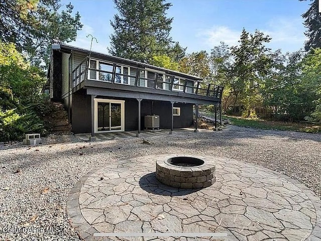 31961 N 3rd Ave, Spirit Lake, ID 83869 - rear view of property featuring an outdoor fire pit, a patio, a wooden deck, and central air condition unit