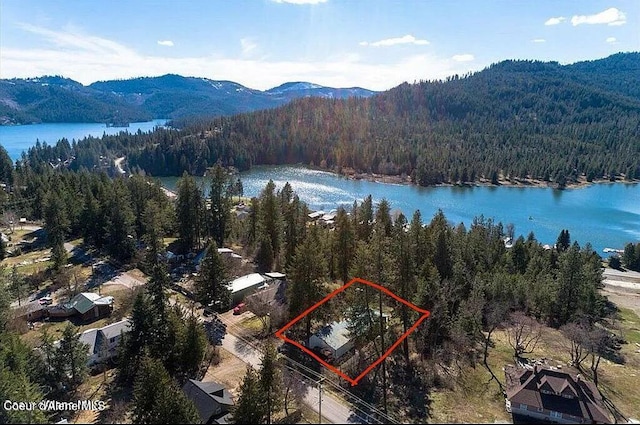31961 N 3rd Ave, Spirit Lake, ID 83869 - aerial overview of property's location featuring a heavily wooded area, property boundaries highlighted, and a water and mountain view