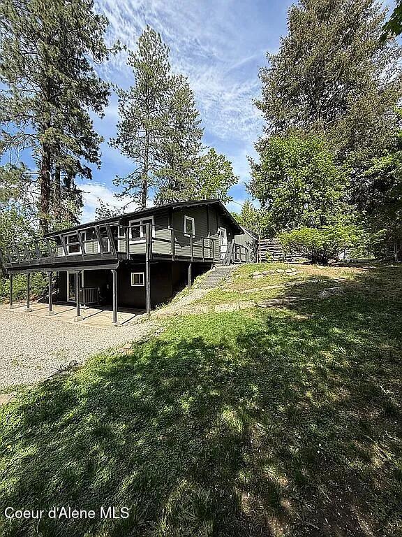 31961 N 3rd Ave, Spirit Lake, ID 83869 - view of front facade featuring a deck, stairs, and a front yard