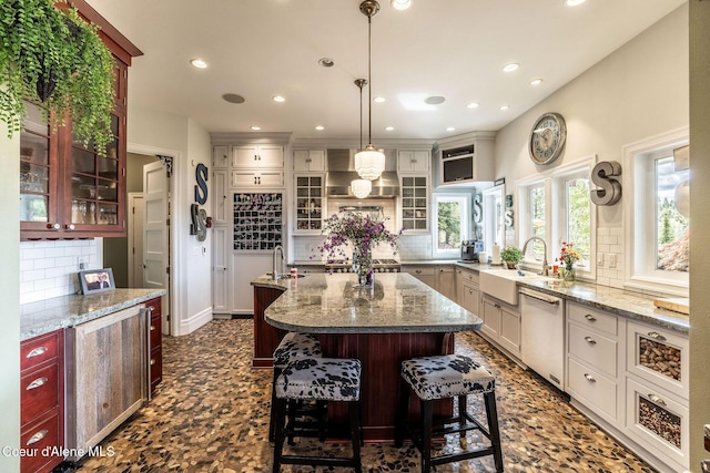 4878 E Annapolis Ct, Coeur Dalene, ID 83814 - kitchen featuring white dishwasher, a sink, tasteful backsplash, an island with sink, and recessed lighting