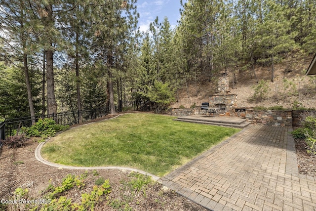4878 E Annapolis Ct, Coeur Dalene, ID 83814 - view of yard featuring an outdoor stone fireplace and a patio area