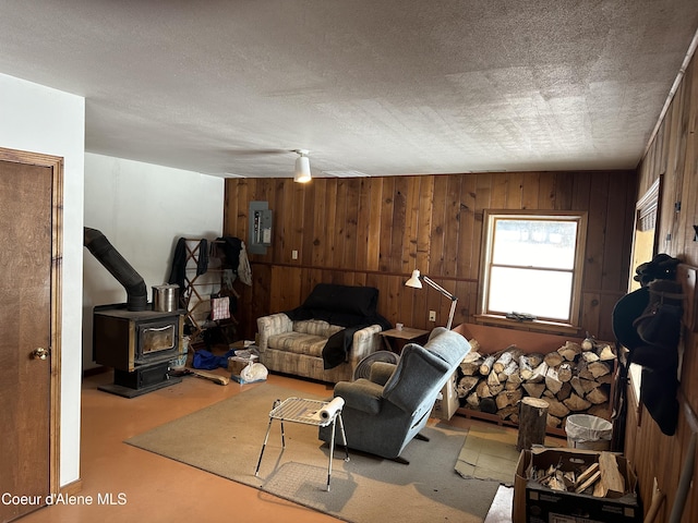 366 Yukon Rd, Bonners Ferry, ID 83805 - living area featuring electric panel, wooden walls, and a wood stove