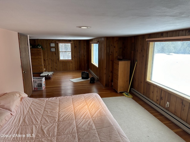 366 Yukon Rd, Bonners Ferry, ID 83805 - bedroom with baseboard heating, wood finished floors, and wood walls