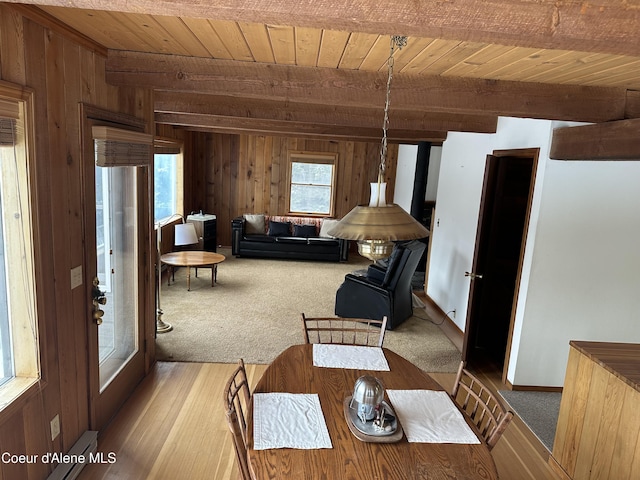 366 Yukon Rd, Bonners Ferry, ID 83805 - carpeted dining area with wood walls, wood ceiling with exposed beams, and baseboard heating