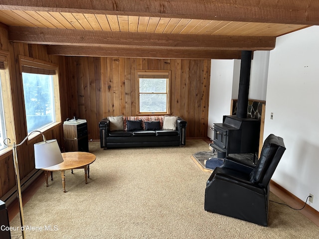 366 Yukon Rd, Bonners Ferry, ID 83805 - living room featuring wood ceiling with exposed beams, wood walls, carpet floors, and a wood stove
