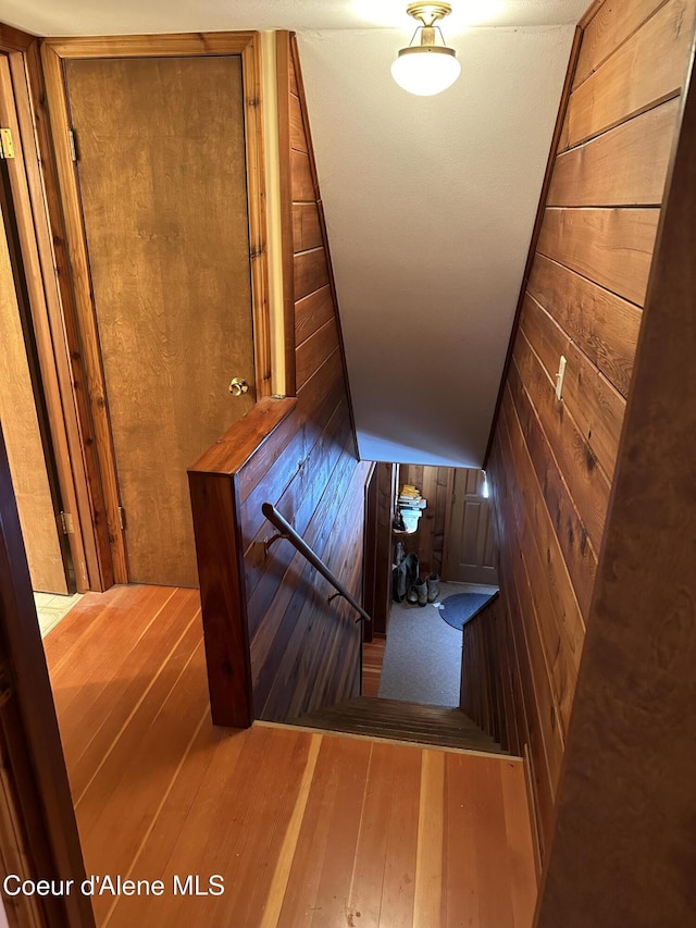 366 Yukon Rd, Bonners Ferry, ID 83805 - staircase featuring wooden walls, hardwood / wood-style floors, and vaulted ceiling