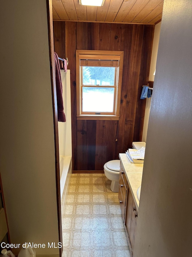 366 Yukon Rd, Bonners Ferry, ID 83805 - full bath featuring wood ceiling, wood walls, tile patterned floors, toilet, and vanity