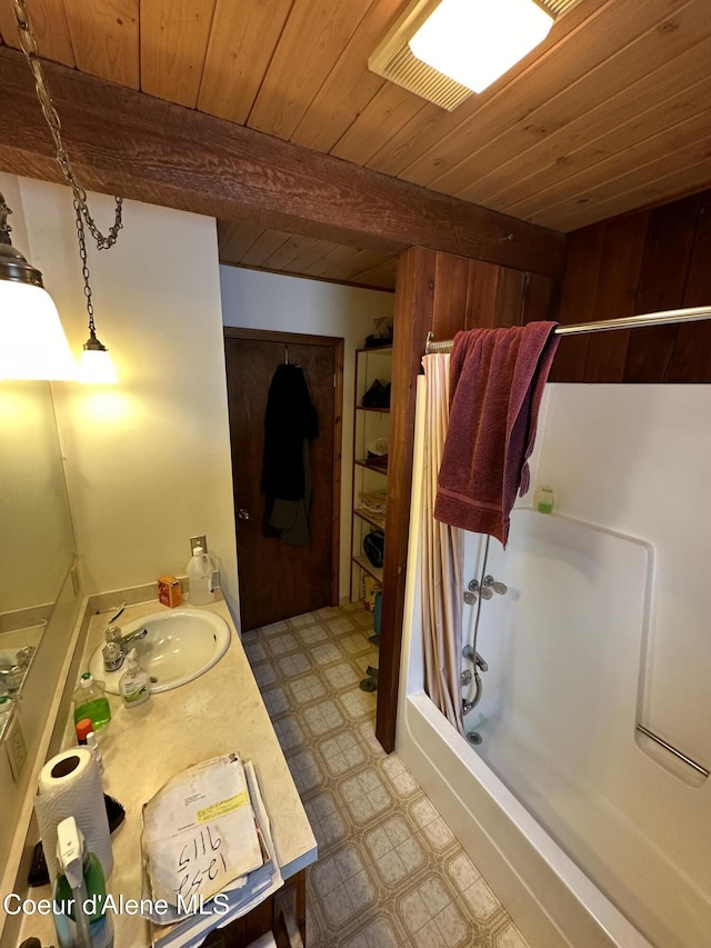 366 Yukon Rd, Bonners Ferry, ID 83805 - full bath with tile patterned floors, wood ceiling with exposed beams, vanity, and shower / bathtub combination with curtain