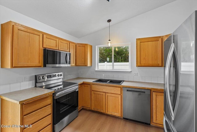 1374 W Timor Ave, Coeur Dalene, ID 83815 - kitchen featuring stainless steel appliances, vaulted ceiling, light countertops, light wood-style floors, and pendant lighting