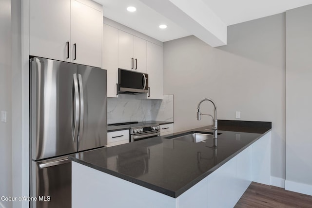 1682 Onyx Ct 1670, 1674 1678, Sandpoint, ID 83864 - kitchen with appliances with stainless steel finishes, dark countertops, a sink, a peninsula, and tasteful backsplash