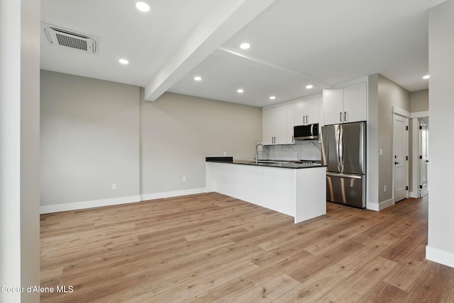 1682 Onyx Ct 1670, 1674 1678, Sandpoint, ID 83864 - kitchen with appliances with stainless steel finishes, a peninsula, dark countertops, light wood-style floors, and baseboards