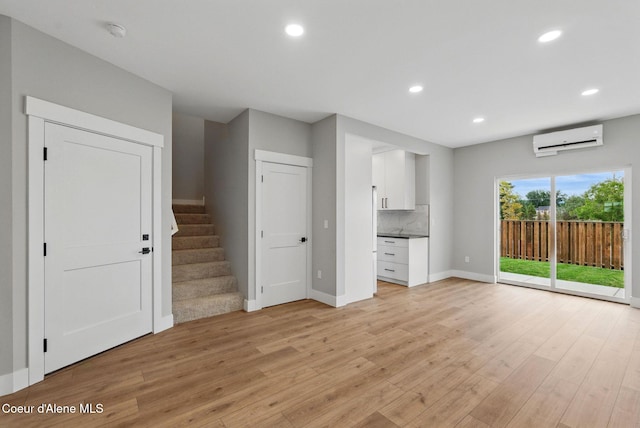 1682 Onyx Ct 1670, 1674 1678, Sandpoint, ID 83864 - unfurnished living room with a wall mounted air conditioner, light wood-style floors, baseboards, recessed lighting, and stairs