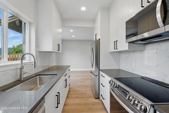 1682 Onyx Ct 1670, 1674 1678, Sandpoint, ID 83864 - kitchen featuring appliances with stainless steel finishes, a sink, white cabinets, recessed lighting, and light wood-style floors