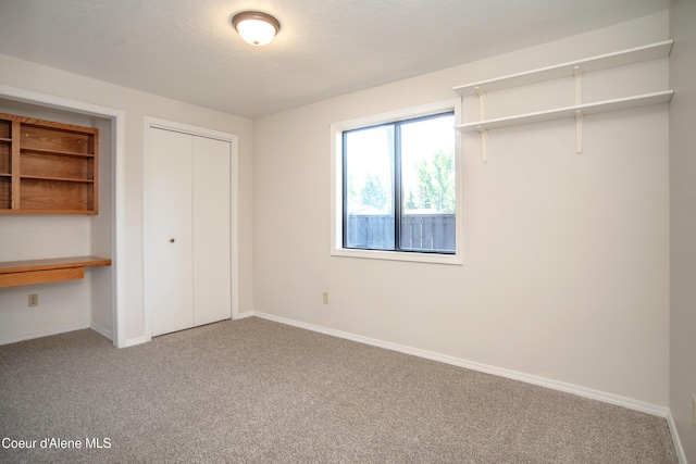 1130 E Timber Ln # 7, Coeur Dalene, ID 83815 - unfurnished bedroom featuring carpet flooring, baseboards, and a closet