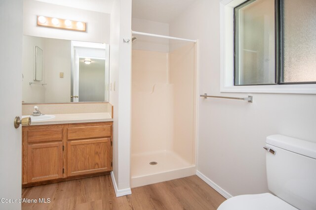 1130 E Timber Ln # 7, Coeur Dalene, ID 83815 - bathroom with wood finished floors, toilet, a shower, vanity, and baseboards