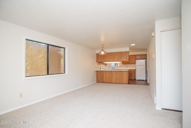 1130 E Timber Ln # 7, Coeur Dalene, ID 83815 - unfurnished living room with light carpet, baseboards, recessed lighting, and a sink