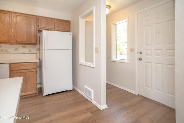 1130 E Timber Ln # 7, Coeur Dalene, ID 83815 - kitchen featuring freestanding refrigerator, light wood finished floors, light countertops, baseboards, and brown cabinets