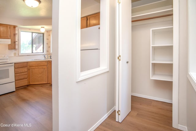 1130 E Timber Ln # 7, Coeur Dalene, ID 83815 - kitchen with white appliances, light wood-style floors, a sink, light countertops, and custom range hood