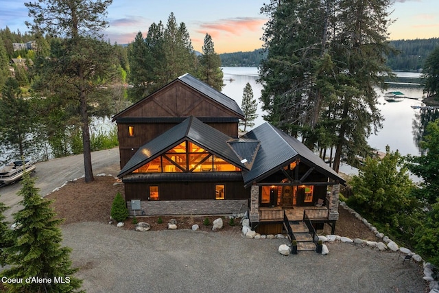 14318 N Waters Edge Ct, Hayden, ID 83835 - view of front of house featuring covered porch, a water view, stone siding, and metal roof