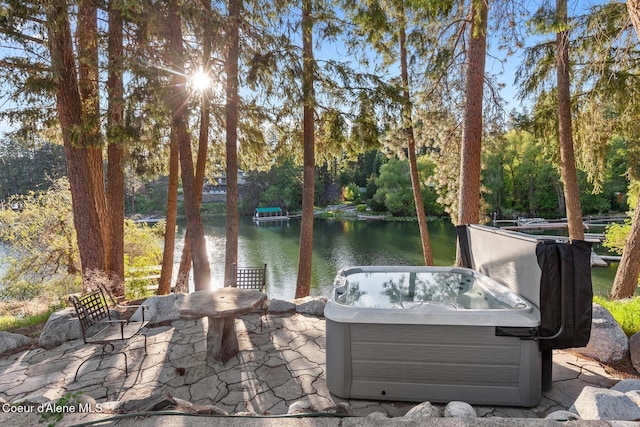 14318 N Waters Edge Ct, Hayden, ID 83835 - view of patio / terrace with a water view, a hot tub, and view of wooded area