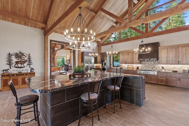 14318 N Waters Edge Ct, Hayden, ID 83835 - kitchen featuring a chandelier, custom exhaust hood, appliances with stainless steel finishes, high vaulted ceiling, and backsplash