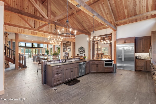 14318 N Waters Edge Ct, Hayden, ID 83835 - kitchen featuring appliances with stainless steel finishes, a chandelier, a sink, high vaulted ceiling, and wooden ceiling with exposed beams