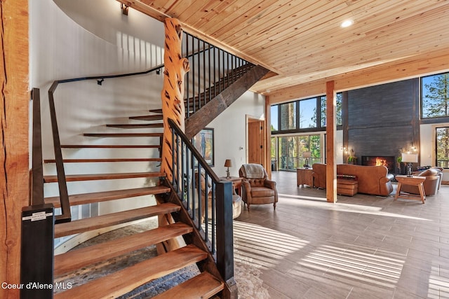 14318 N Waters Edge Ct, Hayden, ID 83835 - staircase featuring a high ceiling, plenty of natural light, wood ceiling, a warm lit fireplace, and recessed lighting