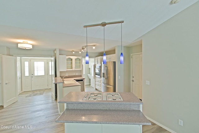 8485 N Audubon Dr, Hayden, ID 83835 - kitchen with appliances with stainless steel finishes, white cabinetry, light wood-style flooring, and light countertops