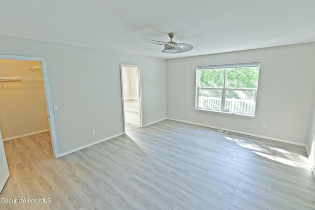 8485 N Audubon Dr, Hayden, ID 83835 - unfurnished bedroom featuring a spacious closet, wood finished floors, a closet, baseboards, and a ceiling fan