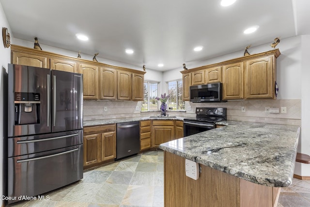 3025 N Sand Trap Way, Post Falls, ID 83854 - kitchen with appliances with stainless steel finishes, a peninsula, a sink, decorative backsplash, and recessed lighting