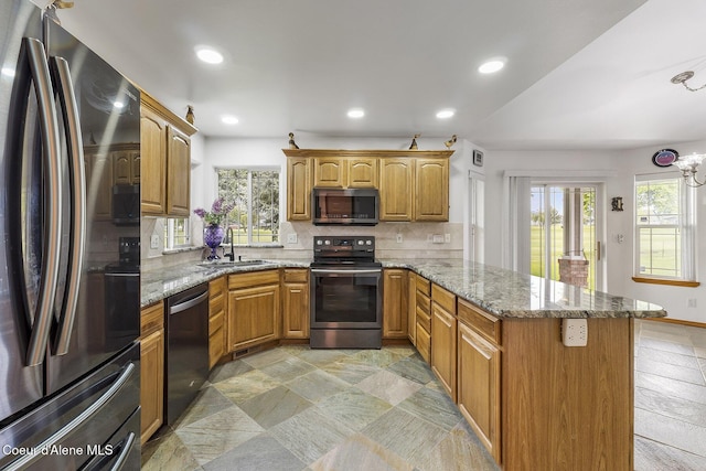 3025 N Sand Trap Way, Post Falls, ID 83854 - kitchen with appliances with stainless steel finishes, a peninsula, plenty of natural light, a sink, and recessed lighting