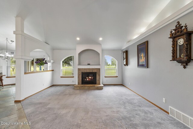 3025 N Sand Trap Way, Post Falls, ID 83854 - unfurnished living room featuring healthy amount of natural light, baseboards, vaulted ceiling, a glass covered fireplace, and carpet floors