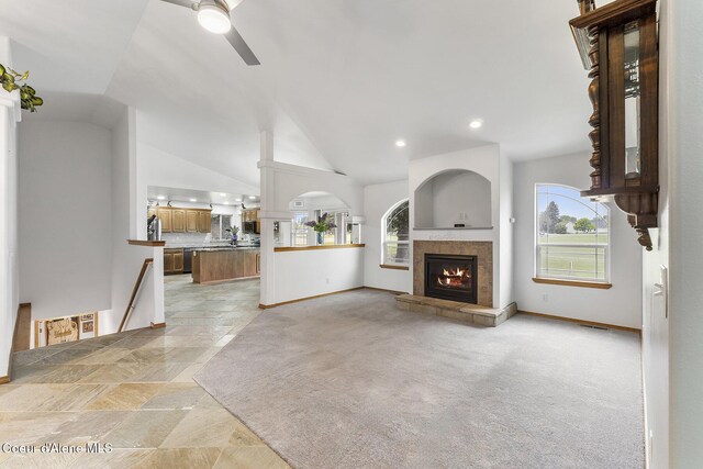 3025 N Sand Trap Way, Post Falls, ID 83854 - unfurnished living room featuring a ceiling fan, a tiled fireplace, baseboards, vaulted ceiling, and recessed lighting